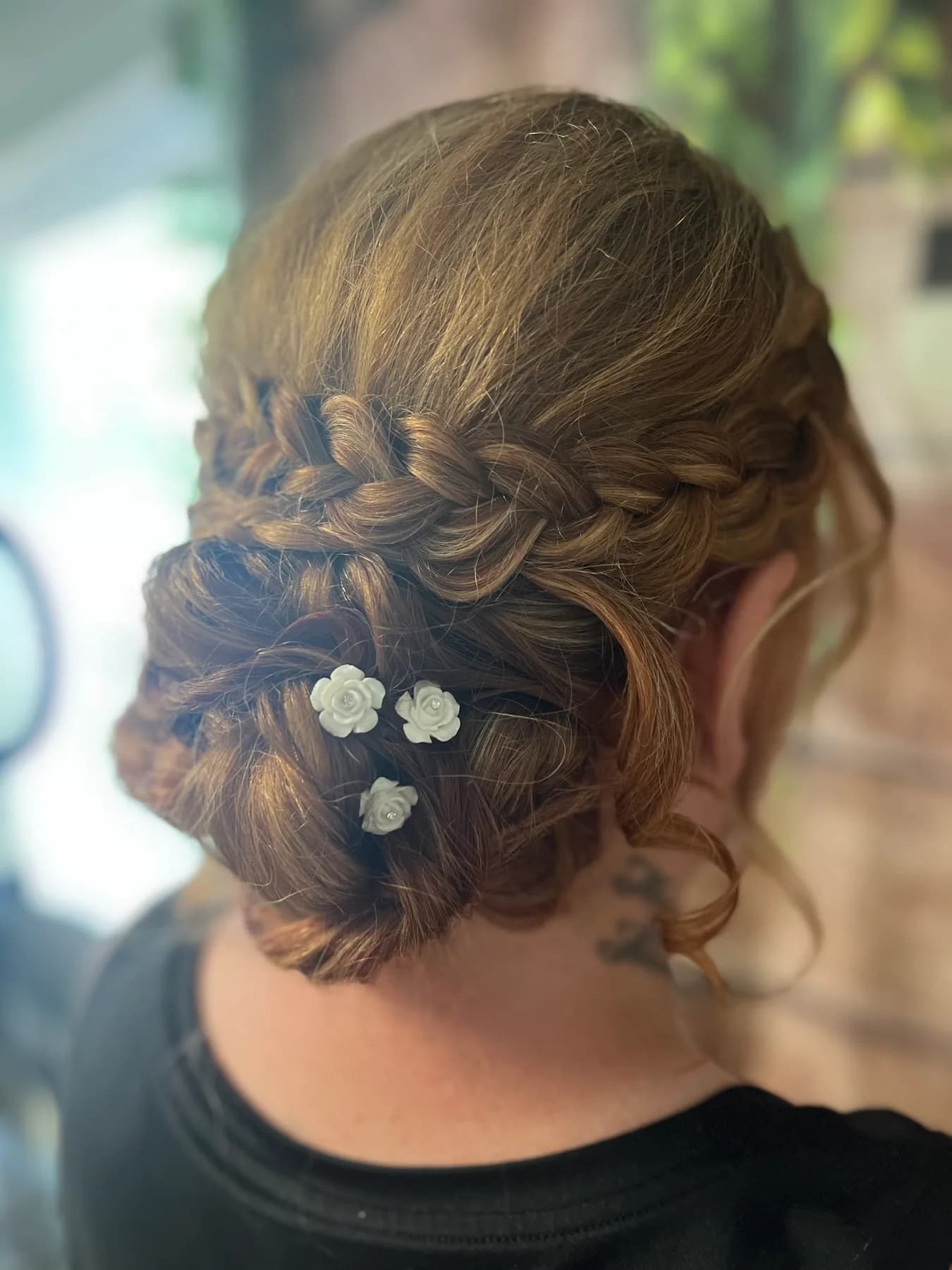 Detailed braided bridal upstyle with floral pins by Hair Haven